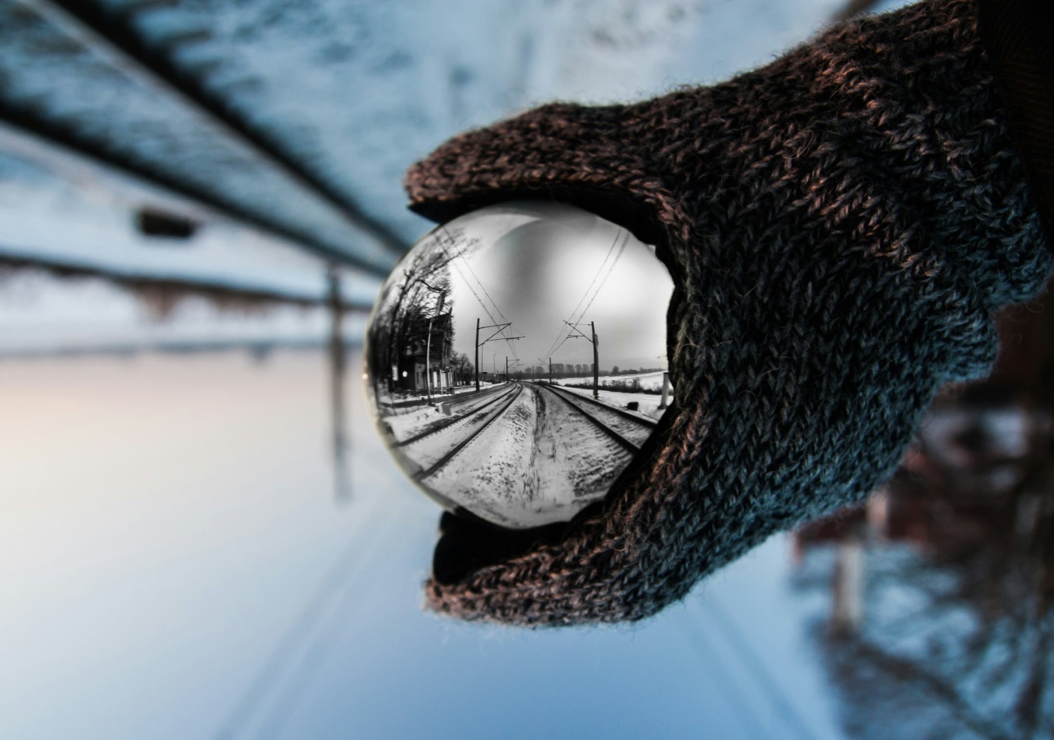 A snowy railway seen through a glass lens